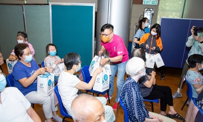 Towngas and HKHS volunteers presented gift bags containing a magnifying glass and health foods for the elderly.