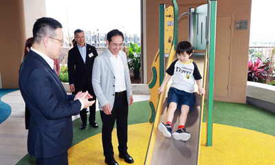 房協行政總裁陳欽勉(左一)與發展局副局長林智文(左三)與首位住戶家庭一同參觀「樂翹樓 1 座」的平台花園及兒童遊樂設施。