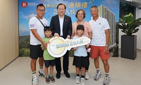房協總監（物業管理）潘源舫 （後排左二）將單位門匙交予「漁映樓」首位入伙住戶鄭太（後排右二）。